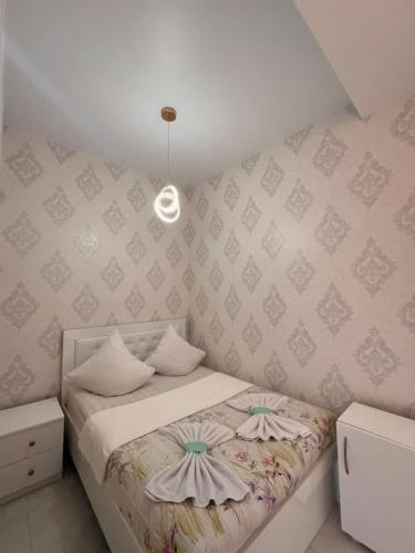 a small bedroom with a bed and a pendant light at Comfortable 5 rooms apartment in Kutaisi