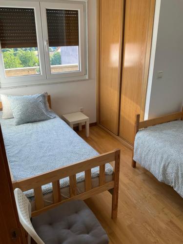 ネグレイラにあるÁvila Apartment - Full Centric Flat with Amazing Viewsのベッド2台と椅子1脚、窓が2つある寝室
