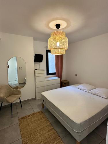 une chambre avec un lit, un miroir et une chaise dans l'établissement super appartement F3 avec jardin, à Pietrosella