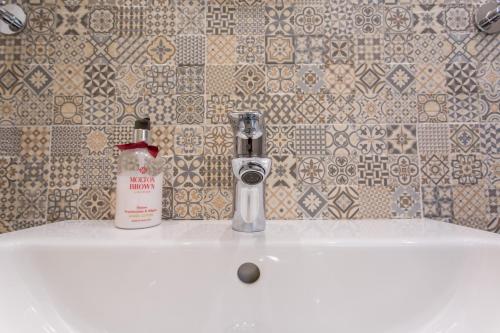 a bathroom sink with a bottle of soap on it at First Hostel in Bucharest