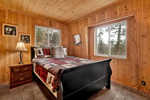una camera da letto con un letto in una cabina di legno di Alpine adventure #2166 a Big Bear Lake