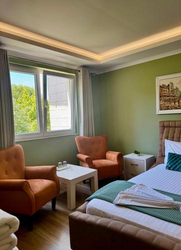 a bedroom with a bed and a couch and chairs at Vila Park Hotel 1 in Tirana