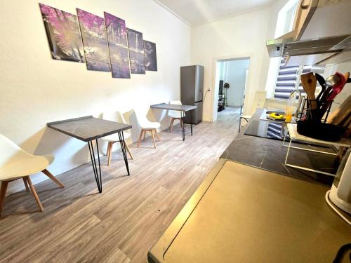 Una cocina y un comedor con mesas y sillas. en Zentrumsnah, 4 Zi, WLAN, 7 P, en Halberstadt