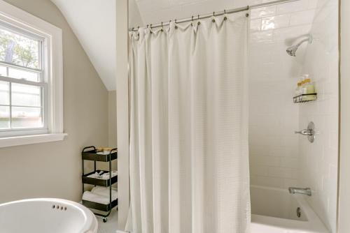 a white bathroom with a shower curtain and a sink at Historic Detroit Bungalow Pet and Family Friendly in Detroit