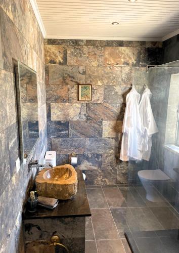 a bathroom with a wooden sink and a stone wall at The Cão & Calf in Faja Grande