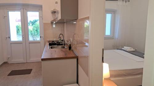 - une cuisine avec évier et un lit dans une chambre dans l'établissement Heritage Studios Sukosan Center, à Sukošan