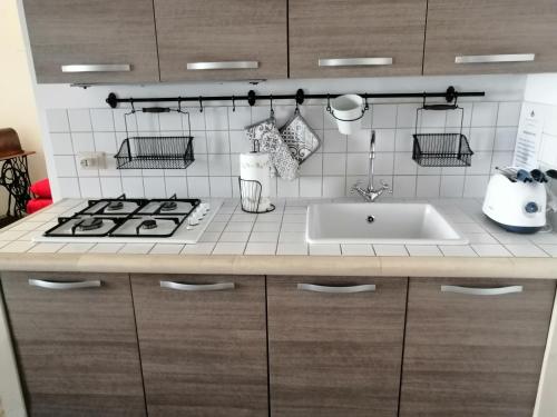a kitchen counter with a stove and a sink at A casa di Marisa in Casamassella