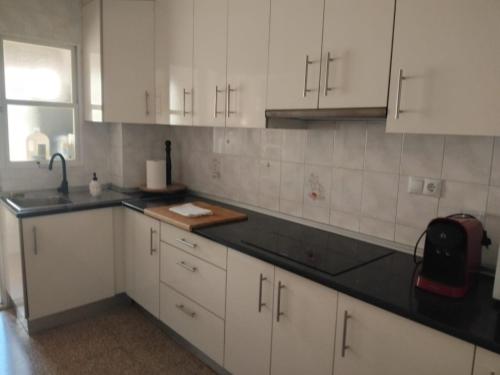 a kitchen with white cabinets and a black counter top at Casa Marquesa in Rojales