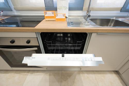 an open dishwasher in a kitchen next to a sink at Casa Giardina in Catania
