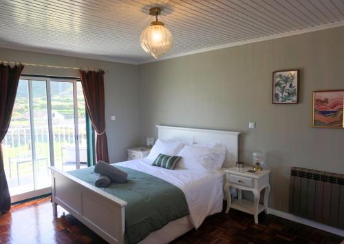 a bedroom with a bed and a large window at The Cão & Calf in Faja Grande