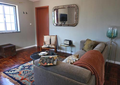 a living room with a couch and a mirror at The Cão & Calf in Faja Grande