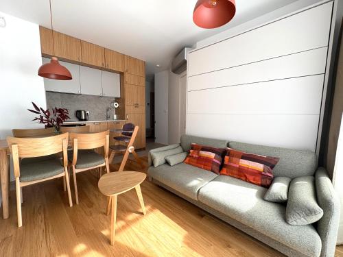 a living room with a couch and a table at Len Apartments One Gdańsk Sobieszewo Baltic Line blisko morza na Wyspie Sobieszewskiej dla rodzin przyjazny zwierzętom z tarasem in Gdańsk