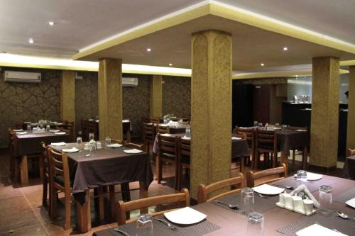 um restaurante com mesas e cadeiras em uma sala em Hotel Haywizz em Port Blair