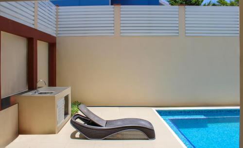 una sedia nera seduta accanto alla piscina di Terry's House a Cozumel