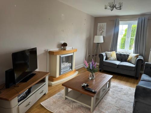 a living room with a couch and a television at Bethel Haven in Great Oakley