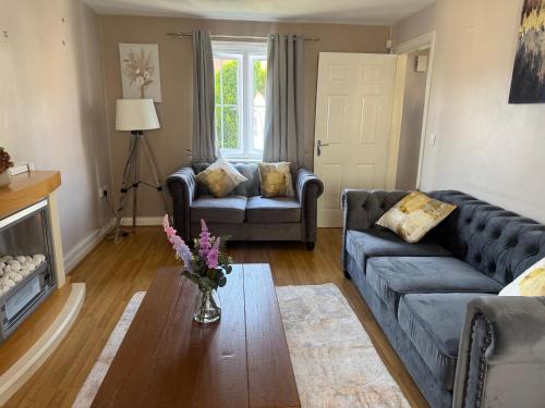 a living room with a couch and a table at Bethel Haven in Great Oakley