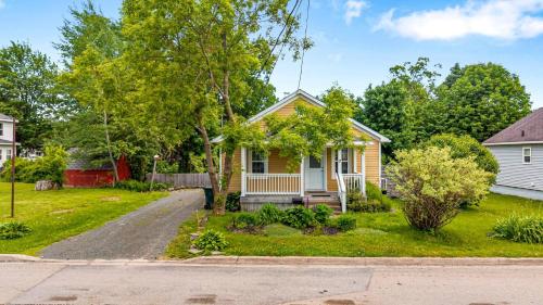 a yellow house with a driveway in front of it at Charming 2BR Bungalow in the Heart of Antigonish in Antigonish