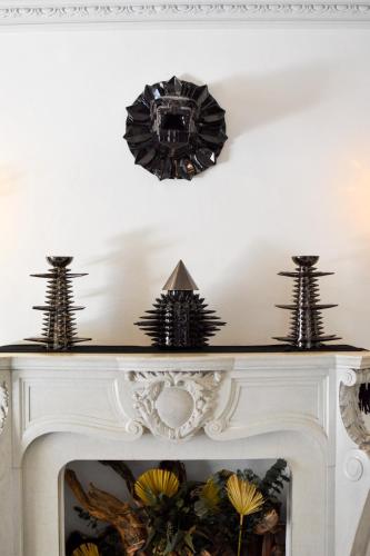 a fireplace with three black sculptures on top of it at Pug Seal Polanco Allan Poe in Mexico City