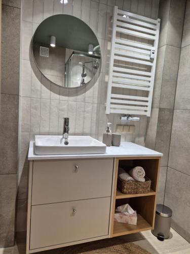 ein Badezimmer mit Waschbecken und Spiegel in der Unterkunft Apartament Morska Harmonia in Ustka