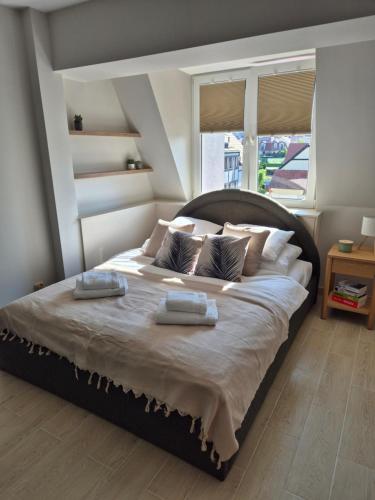 ein Schlafzimmer mit einem großen Bett mit zwei Handtüchern darauf in der Unterkunft Apartament Morska Harmonia in Ustka