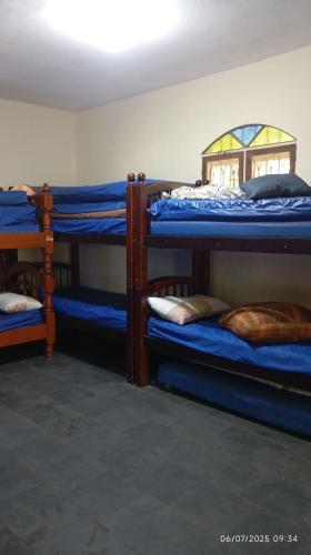 a room with three bunk beds with blue sheets at Sítio Conquista Feliz in Nova Iguaçu