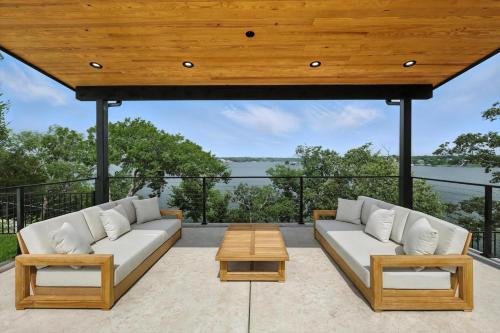 a patio with two white couches and a table at Heavenly Retreat - 5BD of Waterfront Living in Thackerville