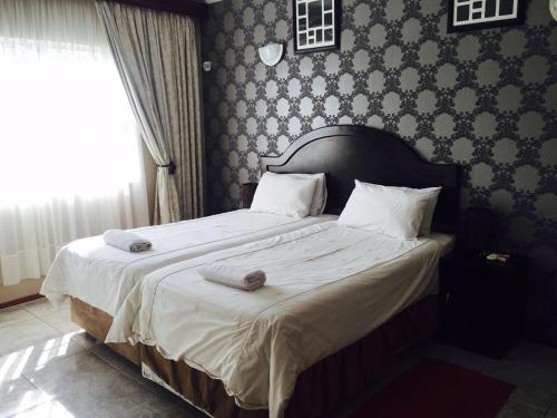 a bedroom with a bed with two towels on it at Logos Guest House in Pietermaritzburg