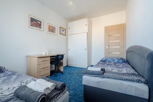 une chambre avec deux lits et un bureau dans l'établissement Team Flat & Urban Family Comfort - HomeBase with a Castle view, à Petržalka