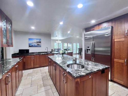 a large kitchen with a sink and a refrigerator at Fantastic 5 Bedroom 4 bath home with new Pool & Jacuzzi in Anaheim