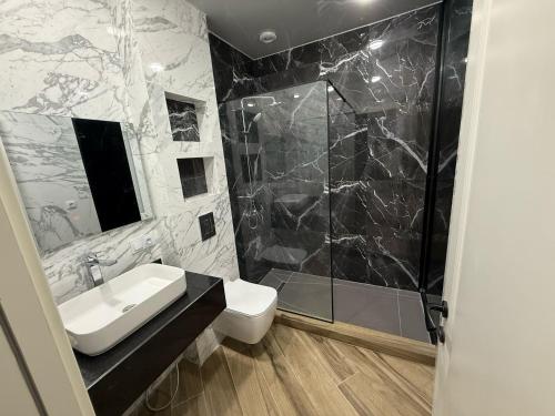 a bathroom with a sink and a shower and a toilet at Villa Sunlight in Gonio