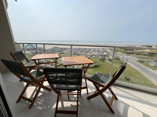 a balcony with tables and chairs and a view of the ocean at Mathilda front de mer 9e étage in Le Touquet-Paris-Plage