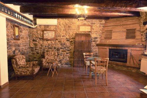a room with chairs and a table and a fireplace at Hospedería La Bogadera in La Robla