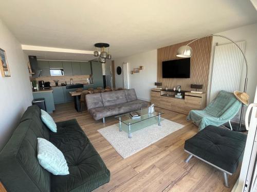 a living room with a couch and a table at Mathilda front de mer 9e étage in Le Touquet-Paris-Plage