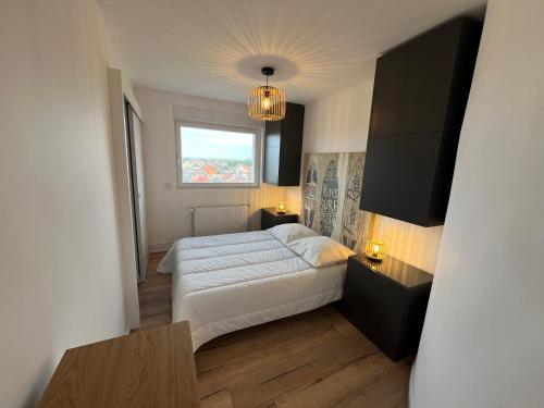a small bedroom with a bed and a window at Mathilda front de mer 9e étage in Le Touquet-Paris-Plage