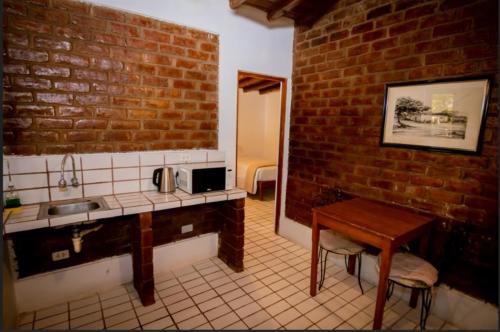 a kitchen with a sink and a brick wall at Hotel Fundo El Arrabal in Ica