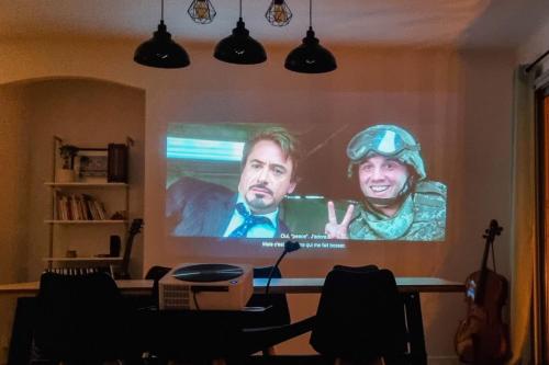 a projection screen with two men on a wall at Beautiful apartment located 5 min from the beaches in La Garde