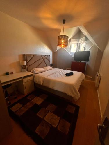 une chambre avec un lit, un bureau et une lampe dans l'établissement Maison calmer & confort, au Mans