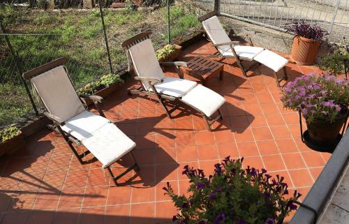 a group of chairs sitting on a patio at Tranquil Tuscan House with Pool and Scenic Views in Rometta