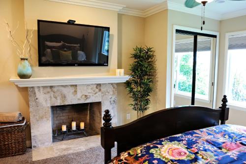 a bedroom with a fireplace with a television above it at Wonderful 4 Bedroom 3 Bath Pool Home 3/4 Mile To Disney in Anaheim
