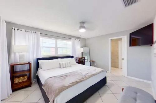 Aqua Vista Cape Coral Waterfront Haven في كيب كورال: غرفة نوم بيضاء مع سرير كبير ونافذة