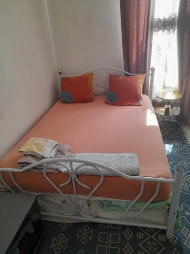 - un lit avec des oreillers orange et orange dans l'établissement Studio abir, à Saint-Ouen