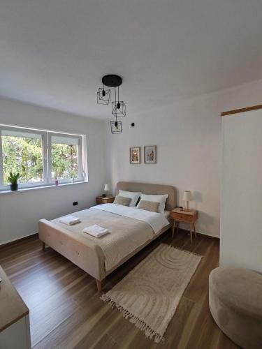 a white bedroom with a large bed and a window at Studio 23 in Banja Luka