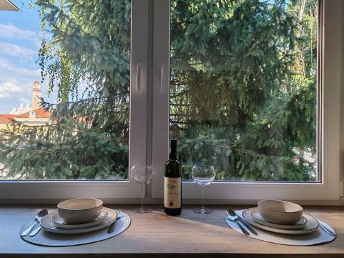 a table with a bottle of wine and a glass at Studio 23 in Banja Luka
