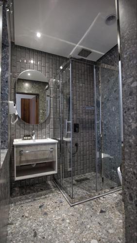 a bathroom with a shower and a sink and a mirror at Cardinal in Quba