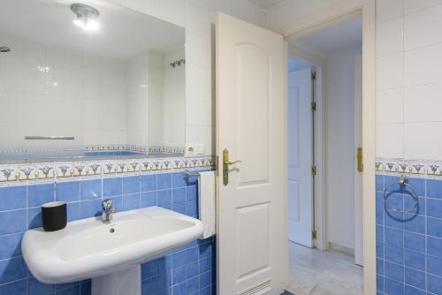 マルベーリャにあるStylish 2-Bed Apartment with Large Terrace & Poolの- 青いタイルのバスルーム(白いシンク付)