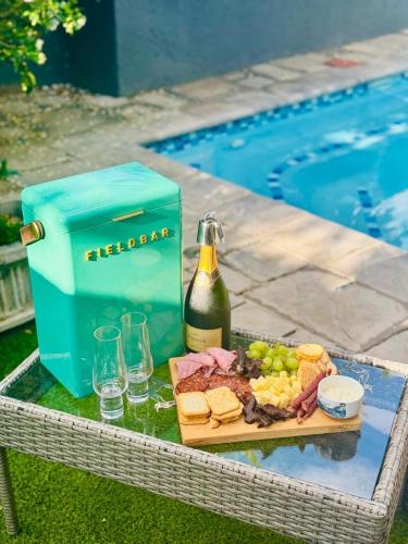 a picnic table with a bottle of wine and food at 13 Orion Aparment in Polokwane