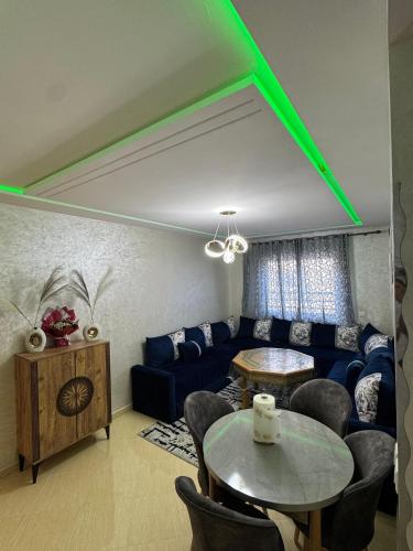 a living room with a blue couch and a table at Comfort Airport House 3min To Airport air-conditioned rooms in Tangier