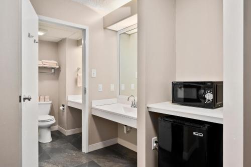 a bathroom with a sink a toilet and a microwave at Second Floor Deluxe Suite Bay View in North East