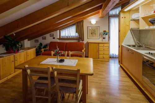 a kitchen with a table and chairs in a room at Apartments in Giustino di Pinzolo 23481 in Giustino