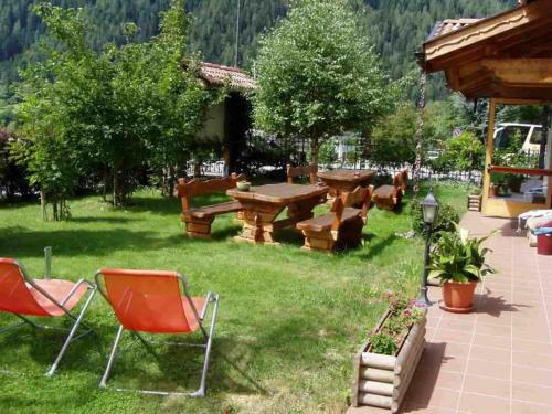 a group of chairs and a picnic table in a yard at Apartments in Giustino di Pinzolo 23481 in Giustino